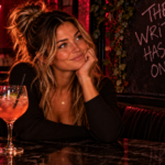 Woman sitting confidently in a dimly lit lounge beneath signs reading “You Already Know” and “The Writing Has Been on the Wall,” representing the moment you stop questioning what the signs have already made clear.