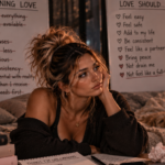 Woman surrounded by reminders of old relationship patterns and healthier expectations, representing the realization that love should bring consistency, safety, and mutual effort—not feel like an exhausting full-time job.